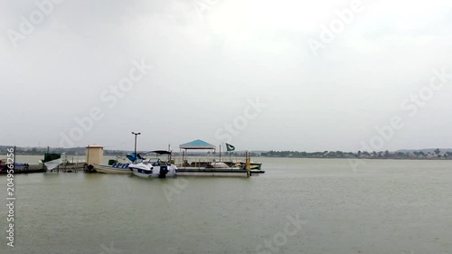 Boat Dock on Calm Lake with Pakistan Flags under Cloudy Sky