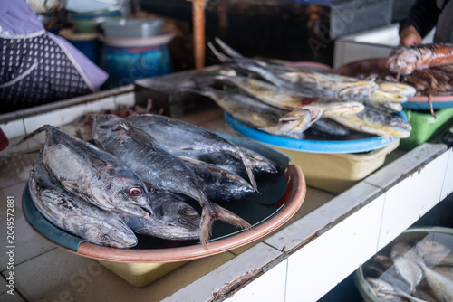 Fresh mackerel tuna, locally known as ikan tongkol, displayed on trays at a traditional fish market in Indonesia.