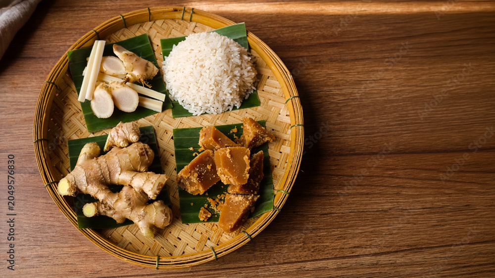 Fototapeta premium Part of Nusantara Harvest, Ingredients for Indonesian jamu on bamboo tray rice ginger palm sugar