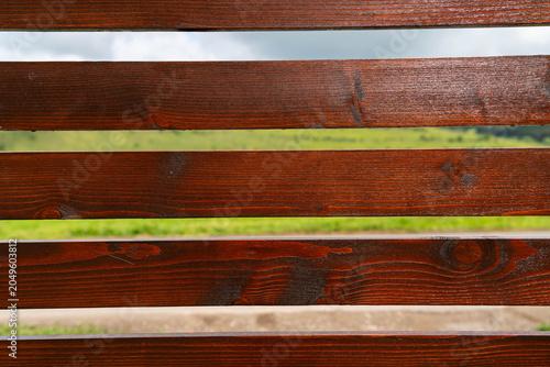Stained pine wood boards on a new residential fence close up shot.