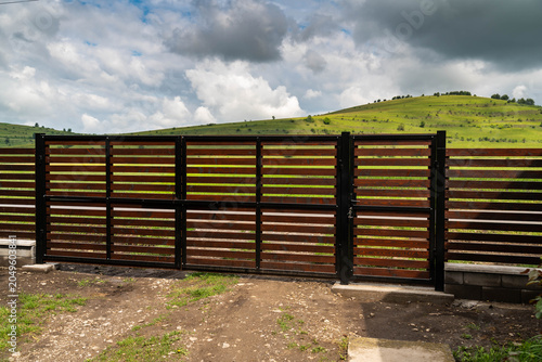 Fotografie New painted pine wood horizontal fence, main gate  with 1 inch gaps between the pine boards