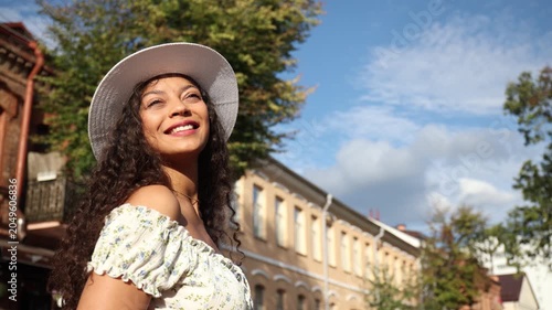 Beautiful young girl walking on a pedestrian street on a summer day, looking over her shoulder