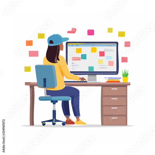 Woman wearing a blue cap working at a computer with sticky notes