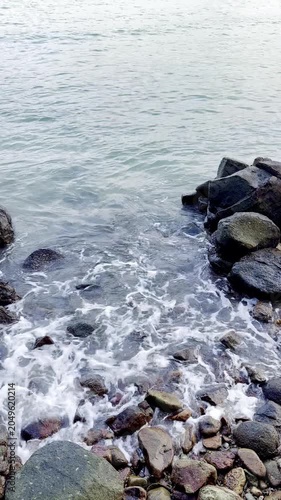 High Angle View of Clear Sea Water Rippling Across Rocky Beach Stones