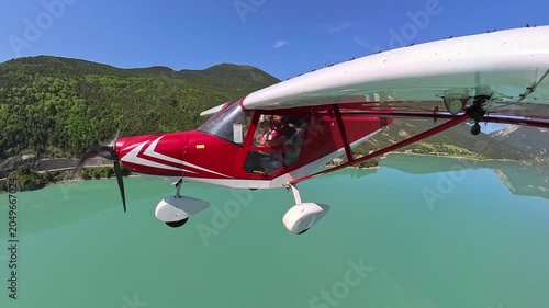 aerial footage, dynamic selfportrait of light airplane flying over turquoise lake of castillon in provence under blue sky