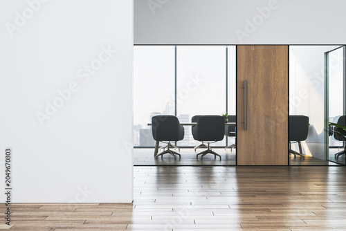 Modern office interior with blank wall and glass meeting room entrance showca...