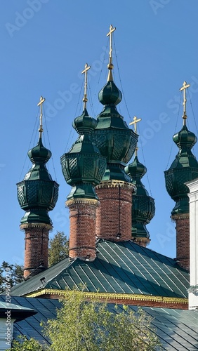 Fotografie Orthodox church with green onion domes against clear blue sky