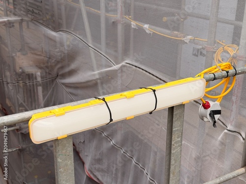 Photos Temporary site light fixed to scaffold rail on construction facade