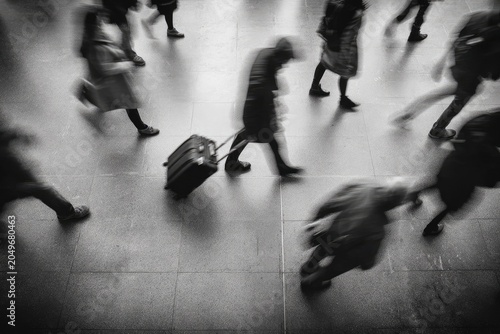 Motion-blurred people with luggage in monochrome