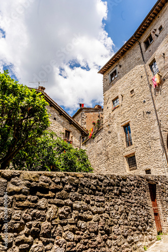 Glimpse of medieval buildings along Via Piccardi, historic stone facades in old town center, Gubbio, Umbria, Italy