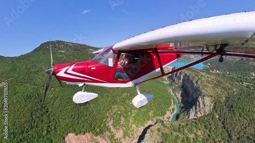 scenic aerial footage, dynamic selfportrait of light airplane flying over canuon in provence under a blue sky