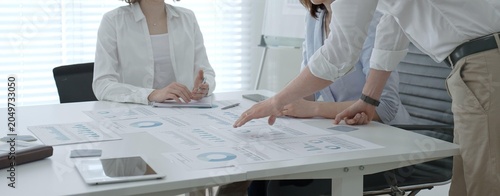 Obraz na plátně Business team collaborating in an office meeting, reviewing charts, reports and