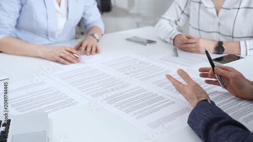 Foto Business partners discussing legal contracts and partnership agreements, reviewi
