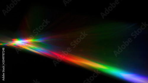 vibrant prism light leak cuts diagonally across dark backdrop creating cinematic rainbow refraction artifact