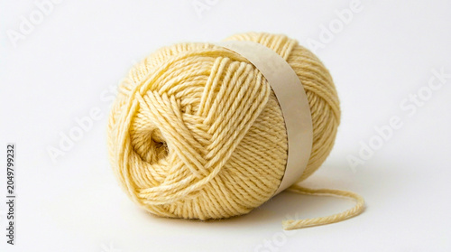 Obraz na plátne Yellow yarn ball with paper label on white surface knitting needlework