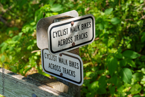 Cyclists are asked to walk bikes across the tracks in a green area