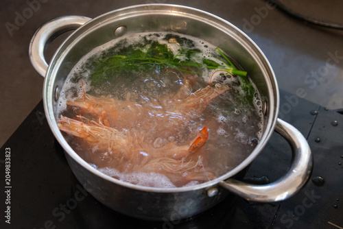 Cooked shrimp served on a white plate. Shrimp cooking in boiling water. Raw shrimp on a white plate