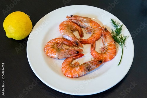 Cooked shrimp served on a white plate. Shrimp cooking in boiling water. Raw shrimp on a white plate