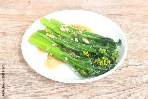 fried green flower Chinese cabbage dressing oyster sauce with chop garlic on plate