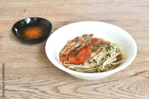boiled slice roasted crispy skin duck meat in black soybean herb soup on bowl dipping spicy sour chili sauce