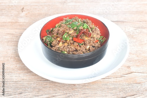 spicy stir fried chop beef meat with chili and basil in bowl on plate