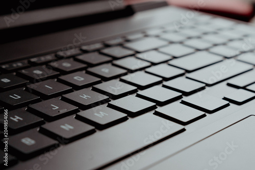 Close-up view of a sleek black laptop keyboard showcasing modern technology and design, ideal for tech enthusiasts and digital workspace visuals.