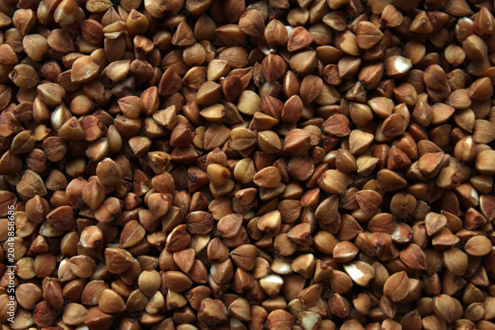 Fototapeta premium Raw buckwheat grains macro texture top view