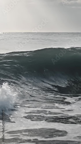 Large ocean wave cresting under bright natural light.