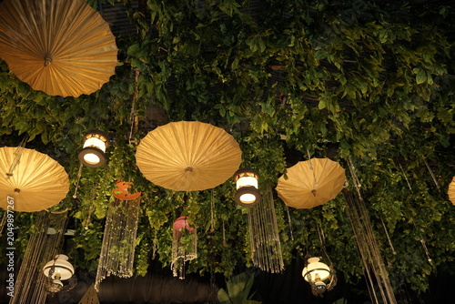 Outdoor party decoration with hanging umbrellas and lush greenery