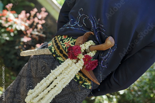 Javanese Traditional Wedding Attire Featuring a Keris Dagger Adorned with Jasmine Flowers for Cultural Ceremony