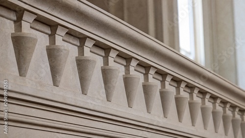 Classical architecture cornice featuring conical guttae details under soft window light.