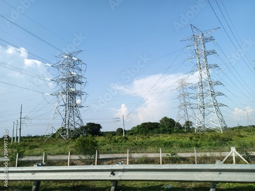 Fotografie Tall electricity transmission towers against blue sky
