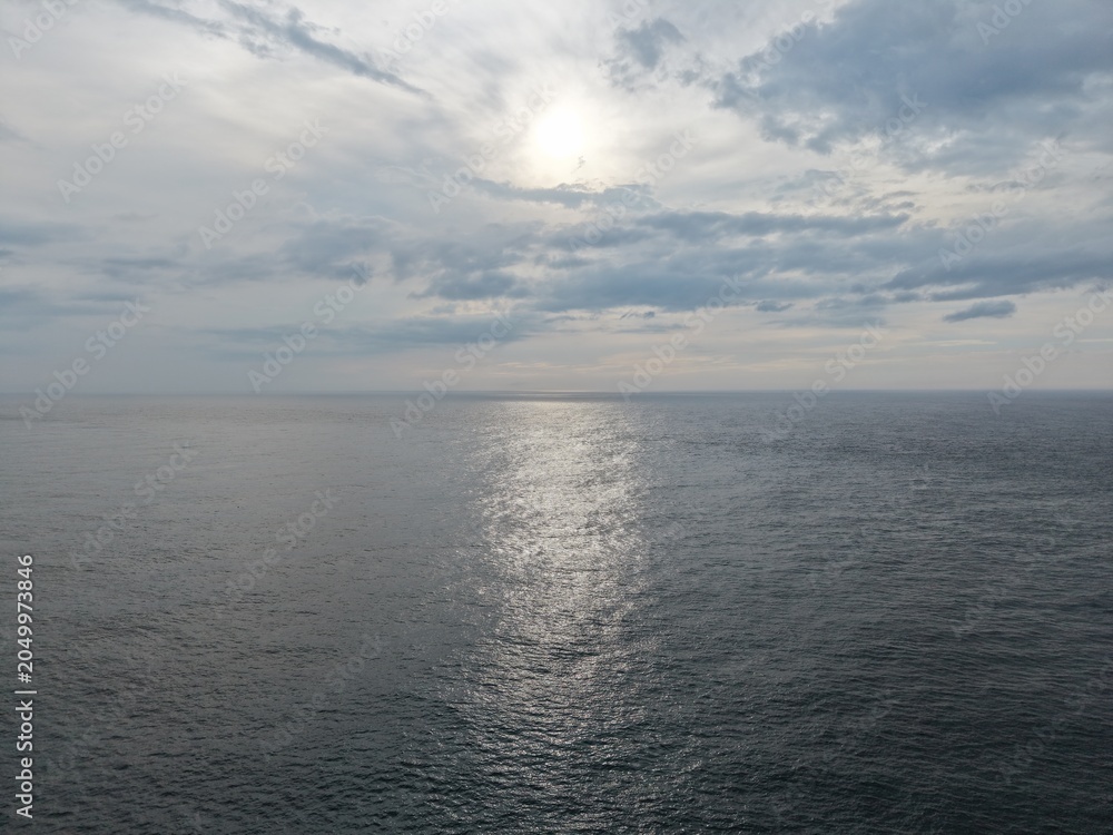 Fototapeta premium Sunlight reflecting on the surface of a vast ocean.