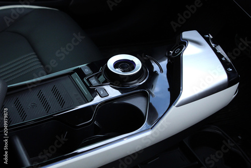 Modern electric car center console with a rotary drive selector, wireless charging surface, and sleek control interface designed for a premium driving experience.
