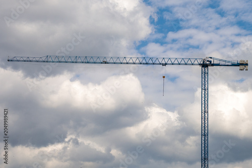 Canvastavla A tall blue tower crane with a long horizontal jib and yellow hook block photogr