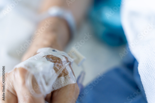 Cuadro en lienzo A close-up of a saline bottle strapped to a needle pricked at the hand of a female patient lying in a hospital bed