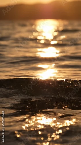 Golden sunset light reflecting on calm ocean water ripples.