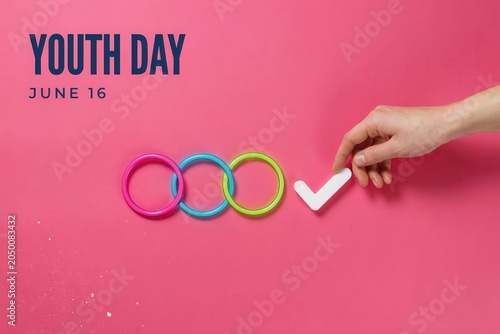 Hand placing checkmark on colorful rings Youth Day June 16