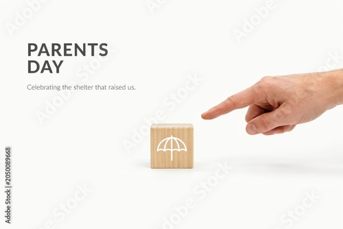 A hand points to a wooden block with an umbrella icon on Parents Day