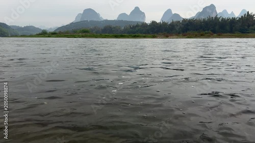 Scenic view from riverbank of fast river current with karst mountains landscape in Guilin, China
