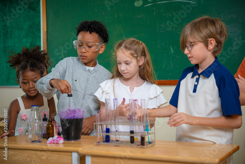 Diversity children doing a chemical experiment in laboratory at school. Kids at elementary school learning science chemistry. Fun study back to school. Education and research. 