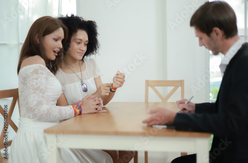 Obraz na plátně Married couple sits affectionately expressing their love and goodwill towards each other transgender woman and handsome foreign man sit holding hands gently demonstrating equality