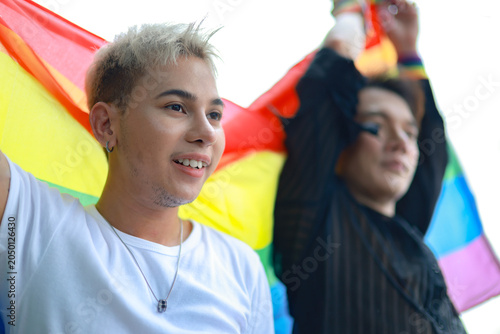 Obraz na plátně Same-sex couples from the LGBTQ community openly and proudly expressed their love and commitment to society by waving Pride flags at a Pride event on International LGBTQ Day