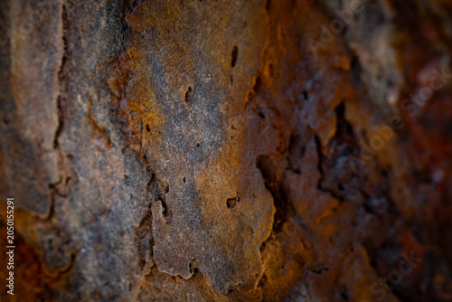 Φωτογραφία Vibrant high saturation macro texture of rustic weathered rock surface with rich orange rust and deep brown earthy mineral tones, warm textured background for graphic design