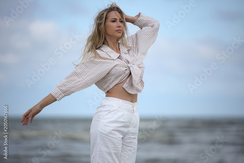 Young Woman Posing on Beach in Striped Shirt