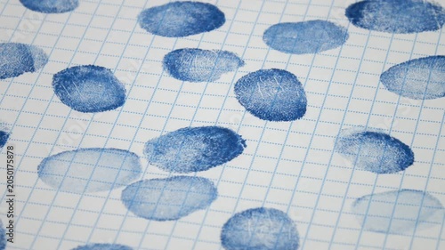 Blue various fingerprints on checkered paper, abstract background