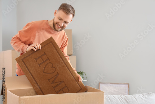 Young man taking doormat ou...