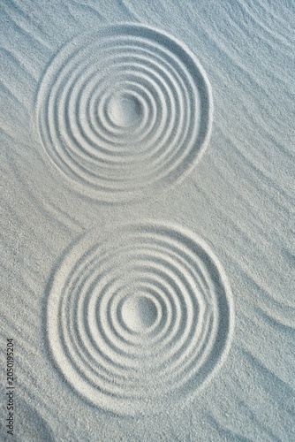 Sand circles forming concentric ripples on sandy surface