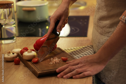 Young man cutting vegetable...