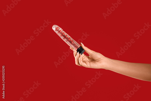 Woman with vibrator on red ...